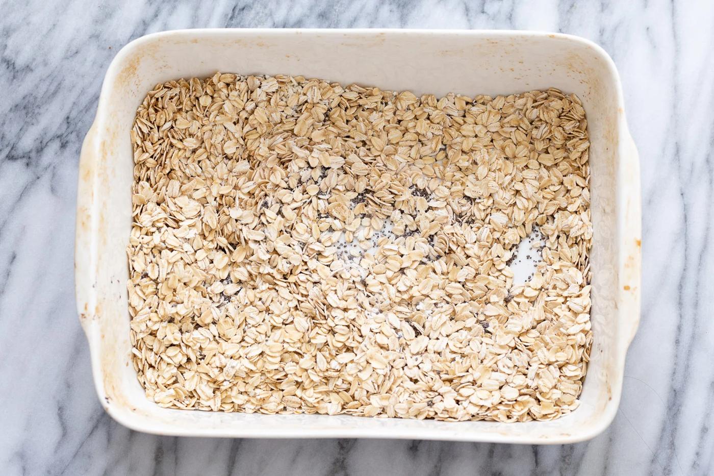 overhead shot of a casserole dish filled with rolled oats and chia seeds