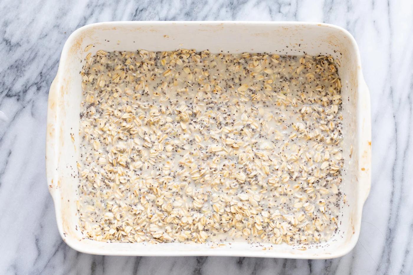 rolled oats and chia seeds being mixed with plant based milk to make baked oatmeal