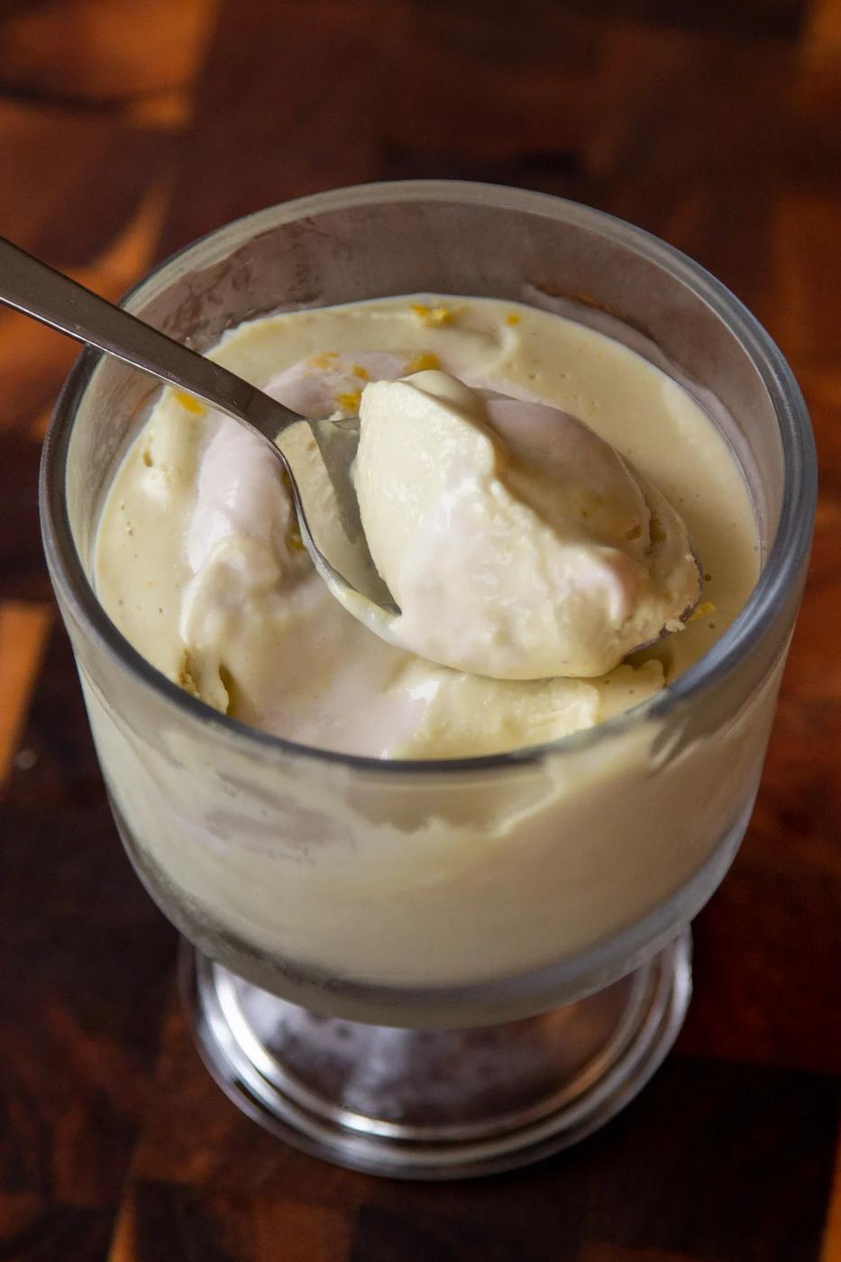 cup of lemon pudding with a spoonful resting on top of it