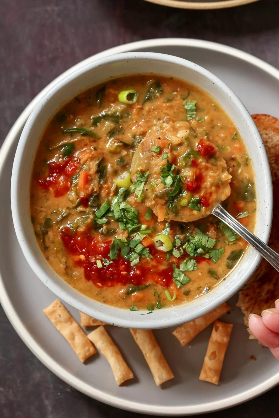 spoon taking a bite of spinach lentil soup