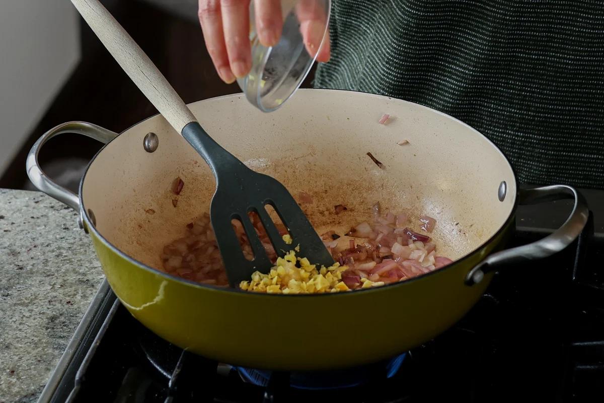 adding ginger and garlic to the pan