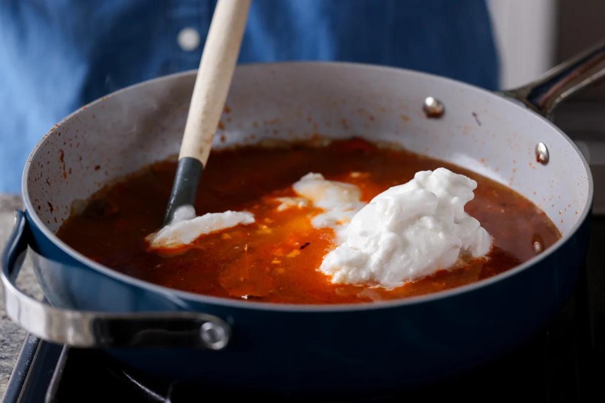 adding coconut milk to the pan