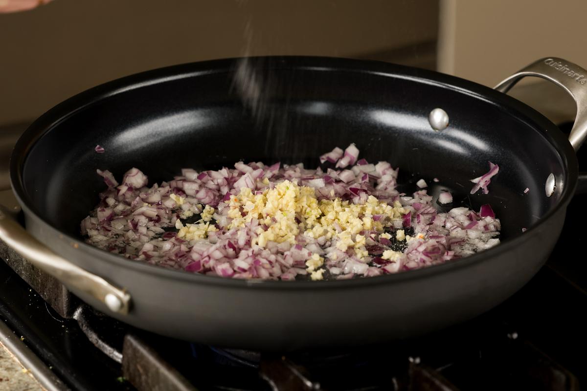 adding onion and garlic to the pan