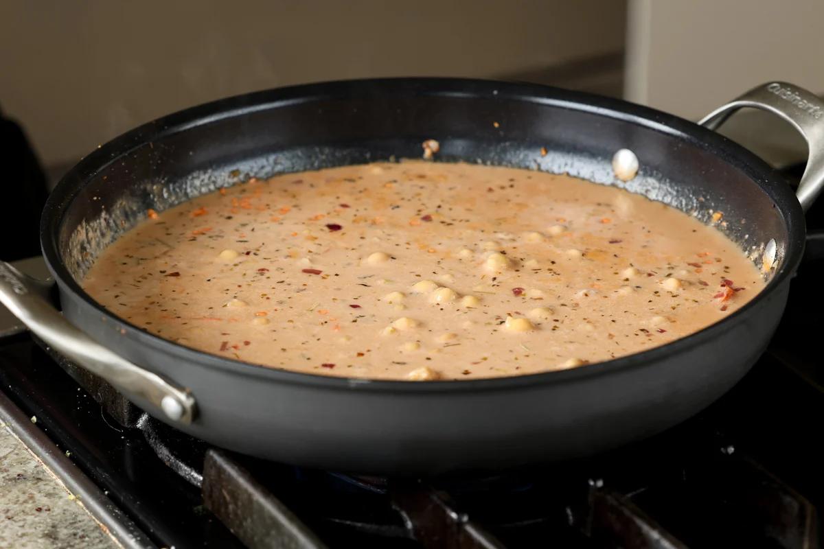 adding chickpeas to the lentil mixture in the pan