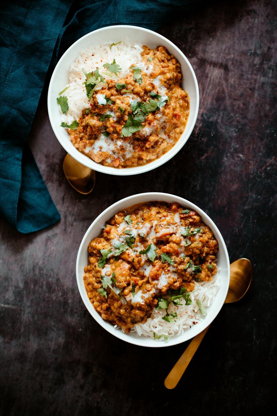 two white bowls filled with rice and vegan Indian Curry Lentil Casserole