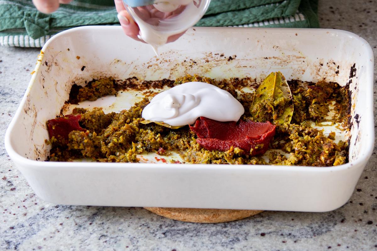 adding non-dairy yogurt and tomato paste to the cooked aromatics