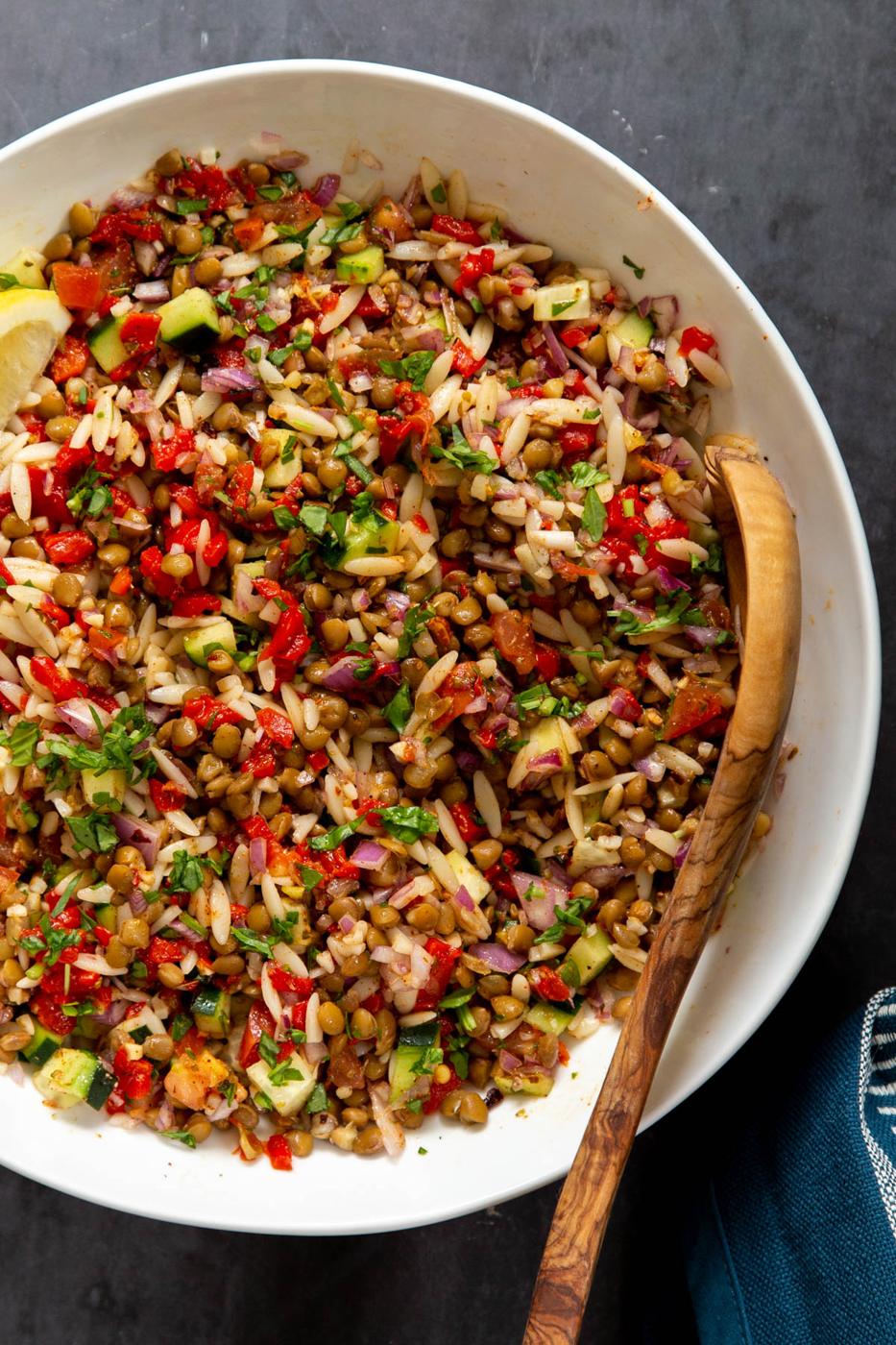 a bowl with vegan lentil farro salad with chopped veggies tossed in lemon vinaigrette