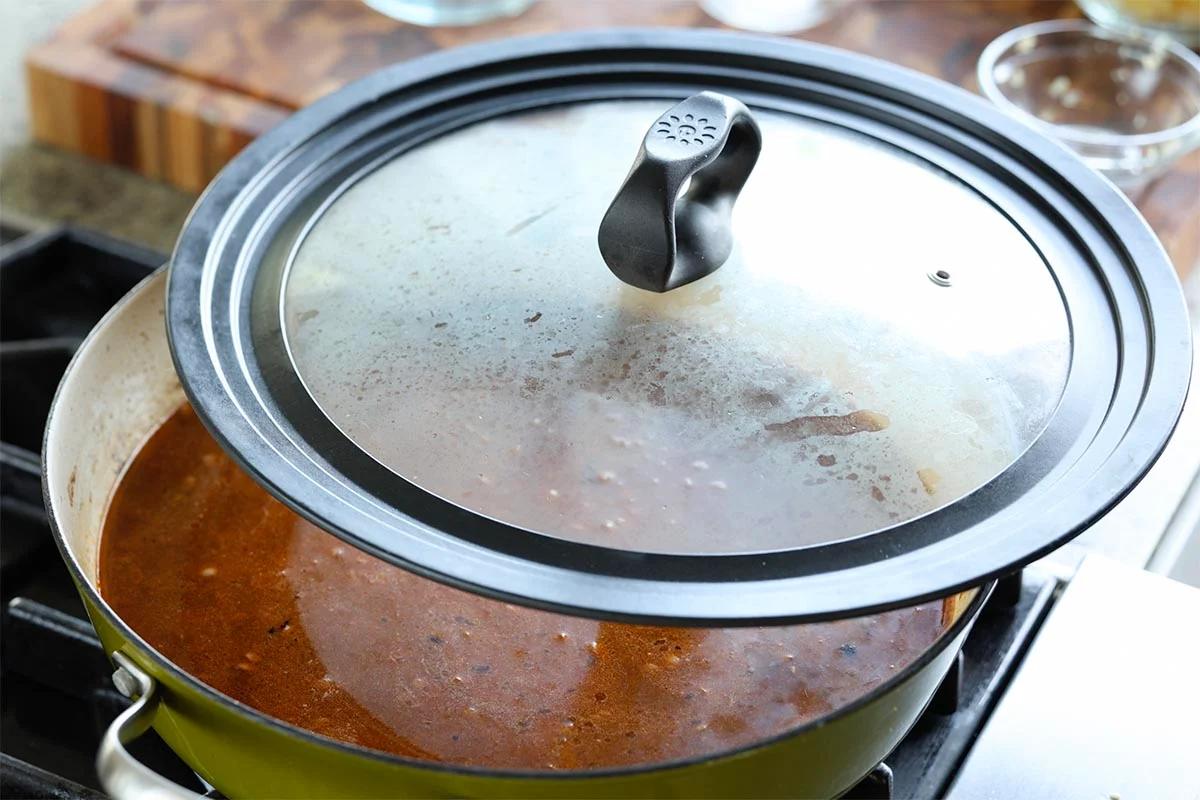 covering the pan with the lid to cook the lentils