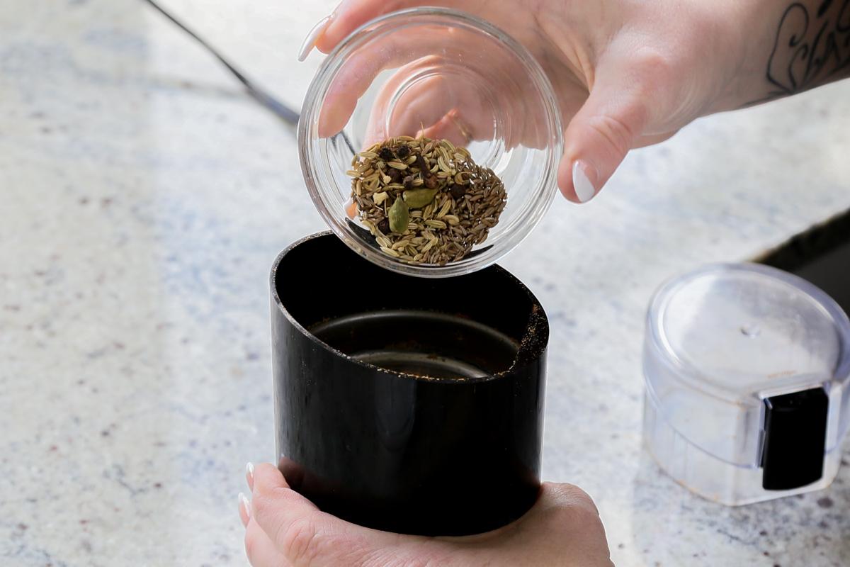 adding spices to a spice grinder