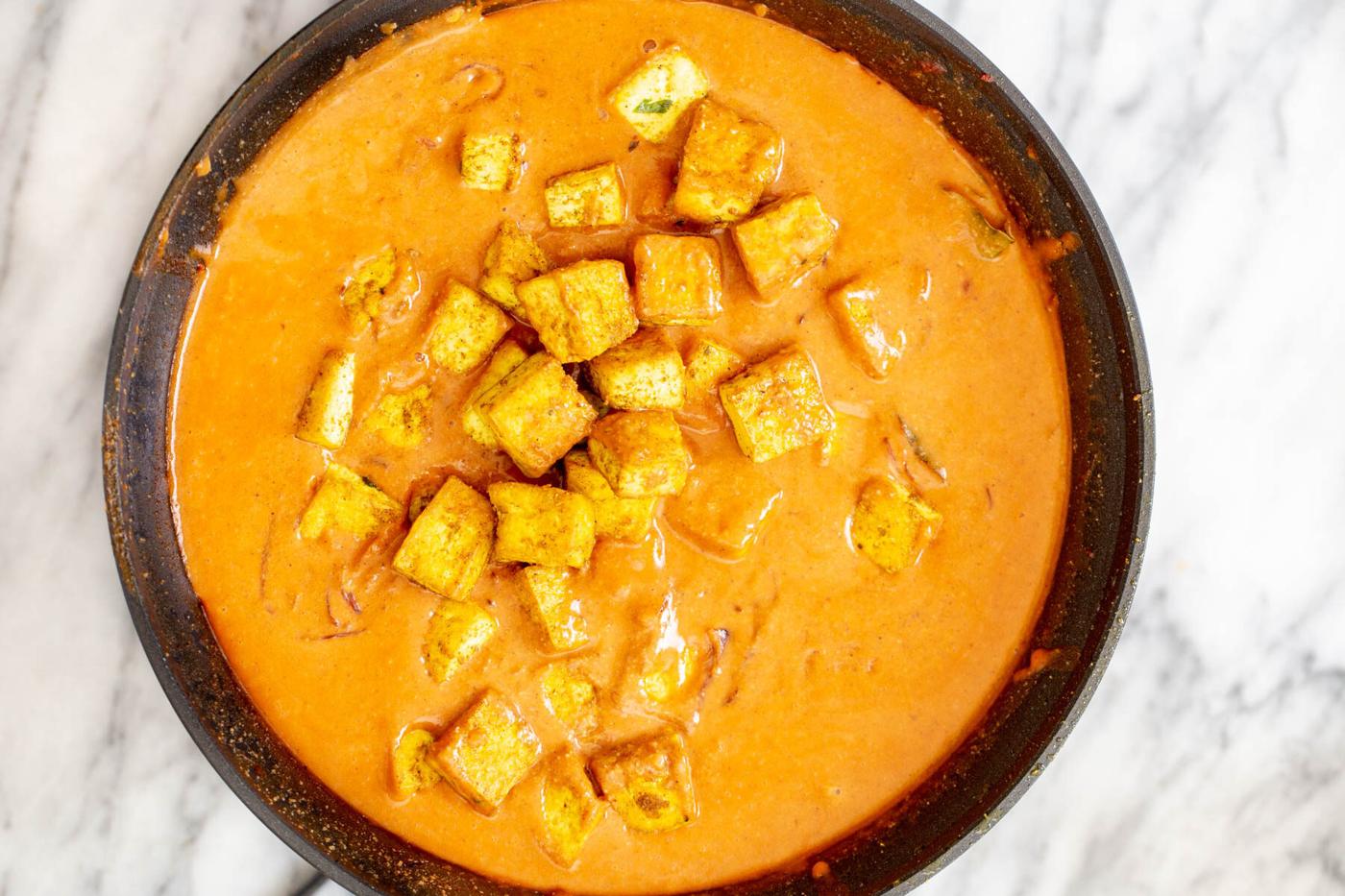 pan-fried tofu cubes in a black frying pan