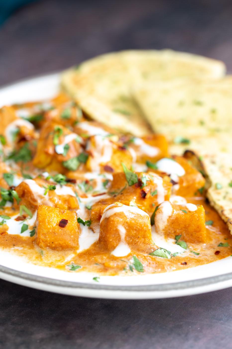 tofu malai curry drizzled with coconut cream served with a side of naan bread