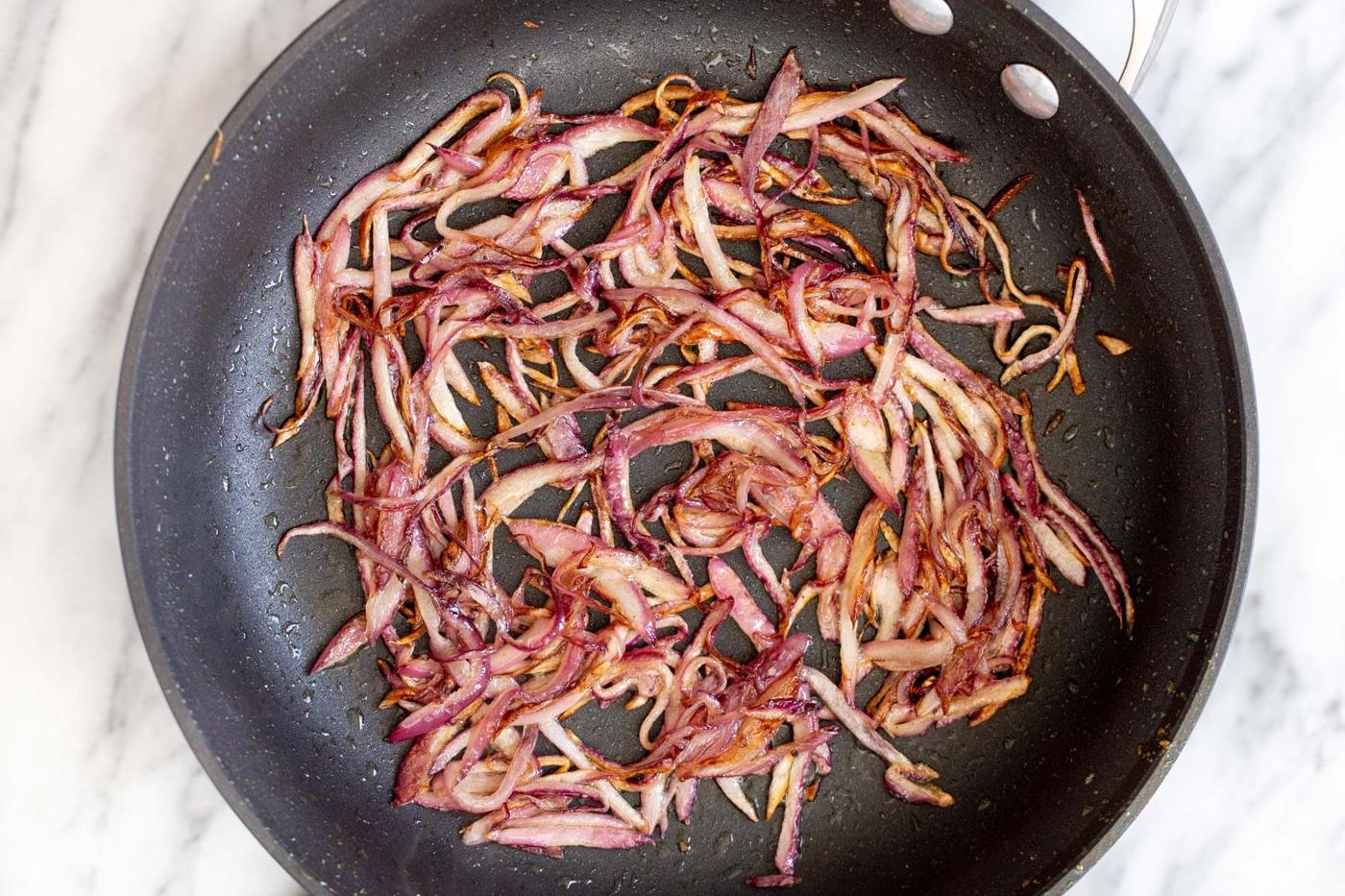 garlic and onion in a black sauteeing pan