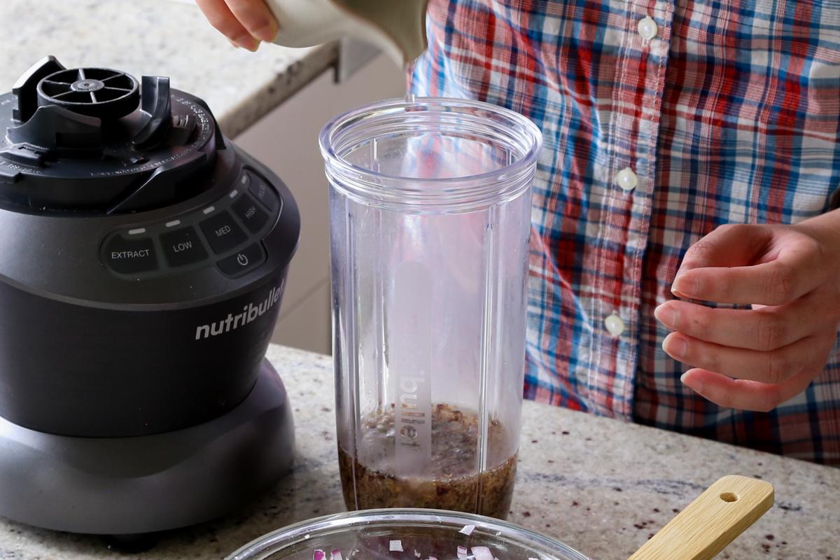 adding water to the coconut mixture in the blender