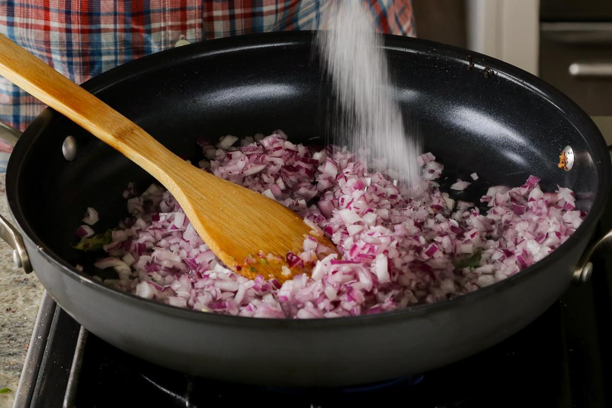 adding onion and salt to the pan
