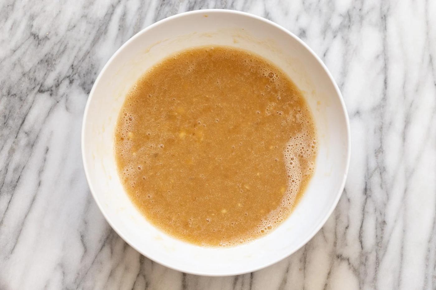 wet ingredients for vegan banana bread being mixed in a small white bowl