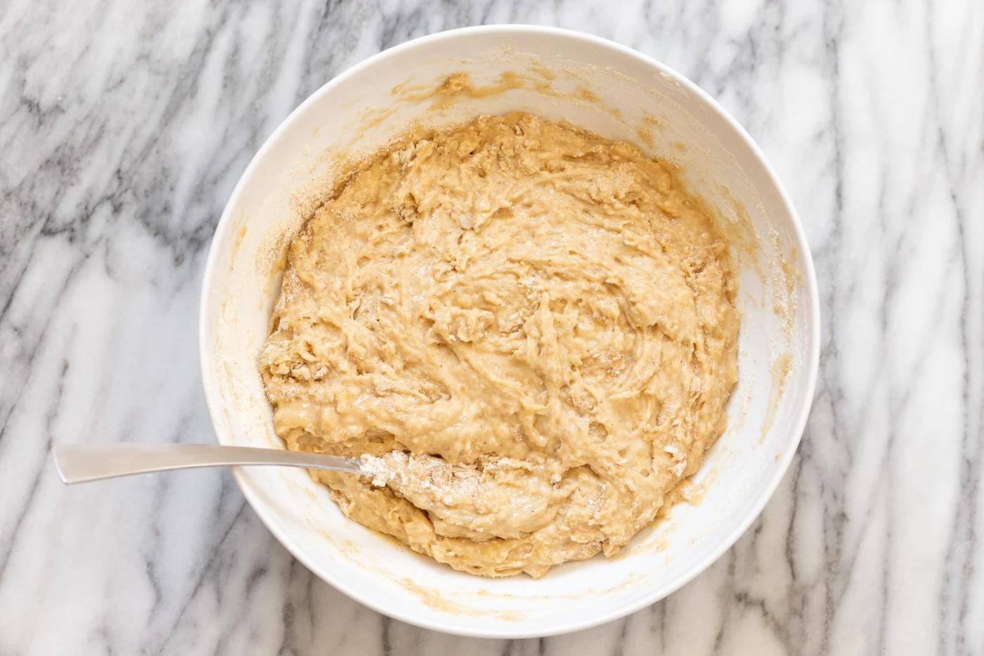 dry ingredients being stirred into wet ingredients to make vegan banana bread