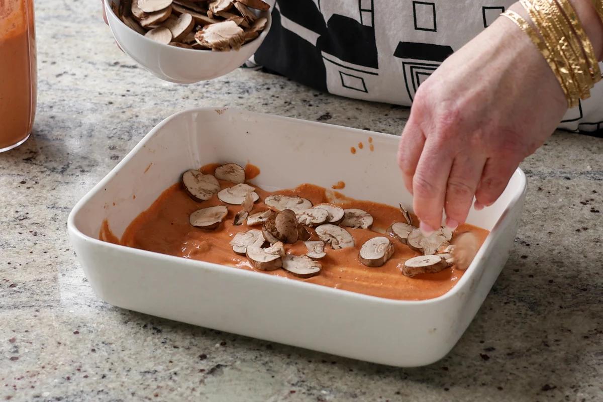 adding mushrooms to the baking dish