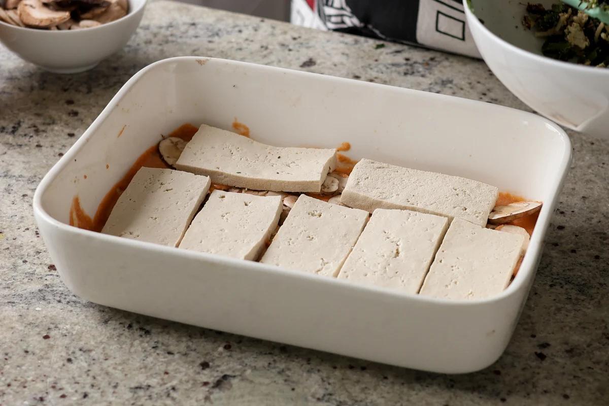 adding tofu to the baking dish