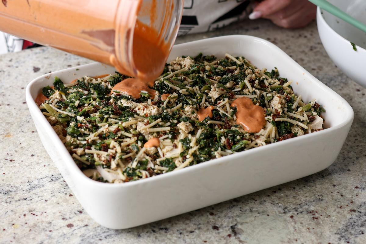 adding dollops of leftover sauce on top of the spinach filling