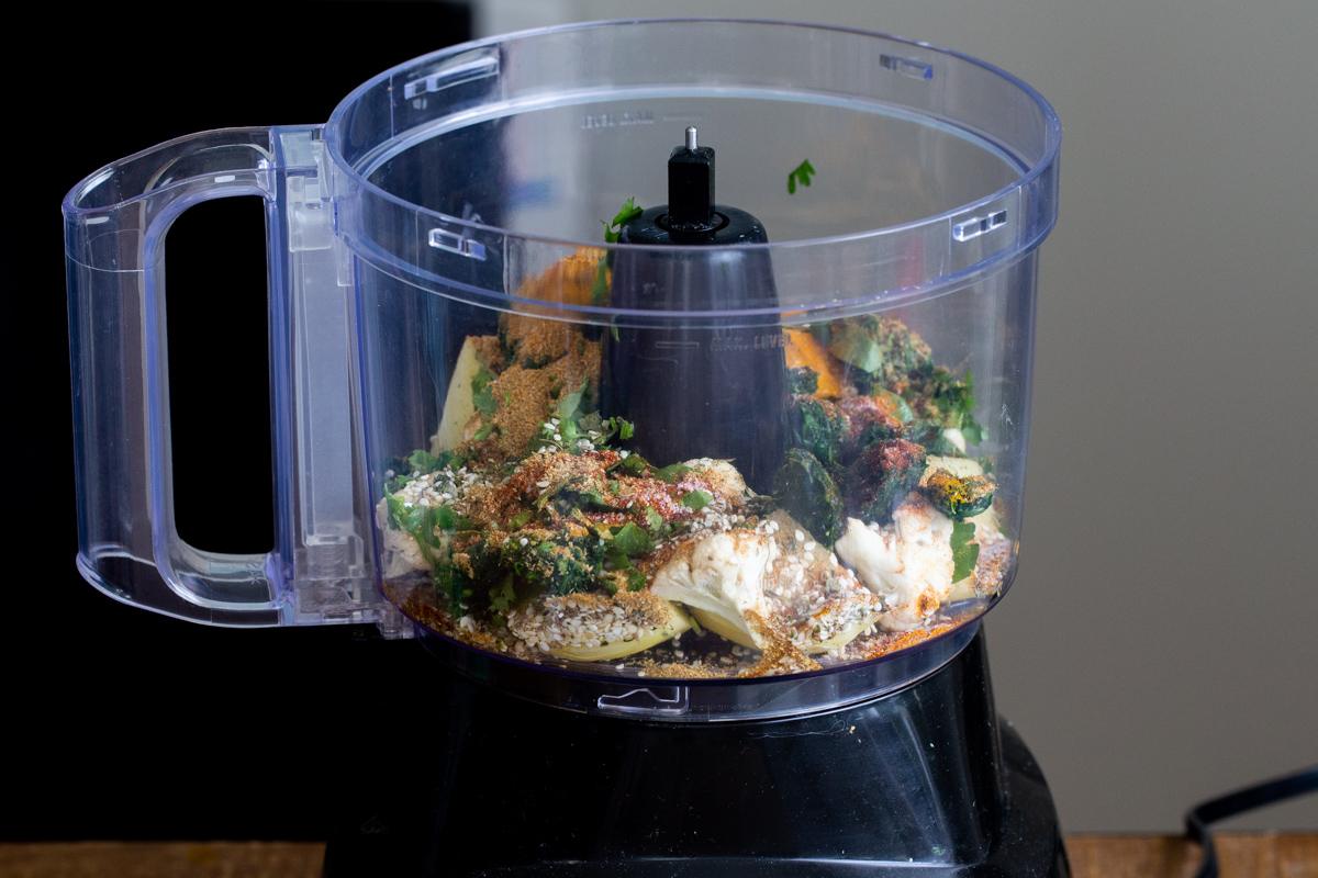 veggies and flour in the container of a food processor