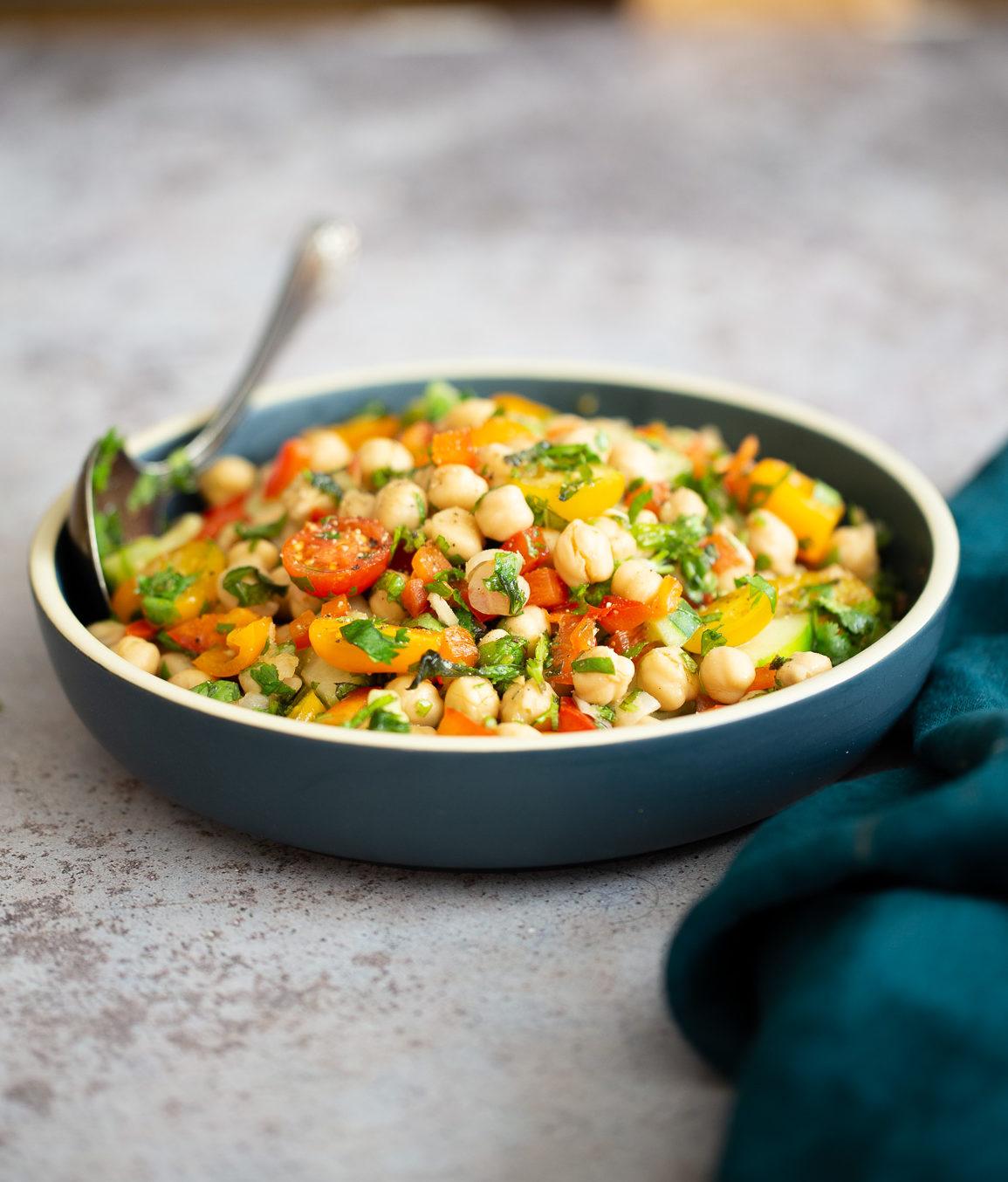 side view of a dish of Mediterranean vegan chickpea salad with lemon garlic dressing