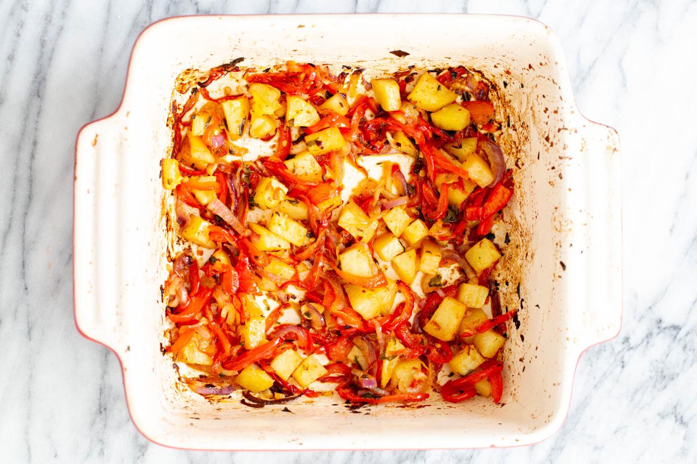 roasted bell peppers, onion and potatoes in a casserole dish