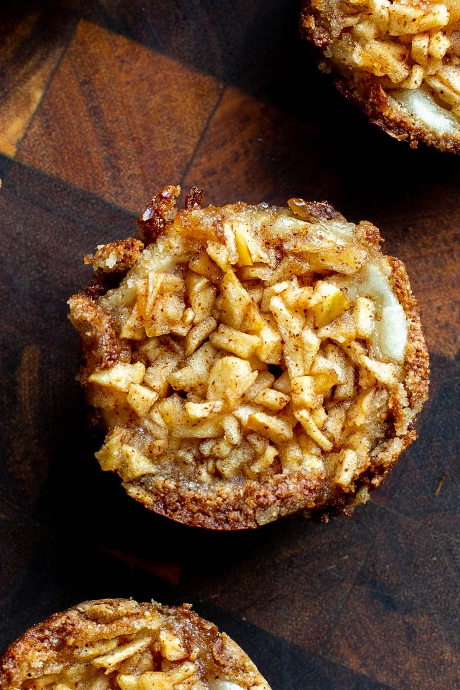 overhead shot of mini vegan apple pies on a wooden board