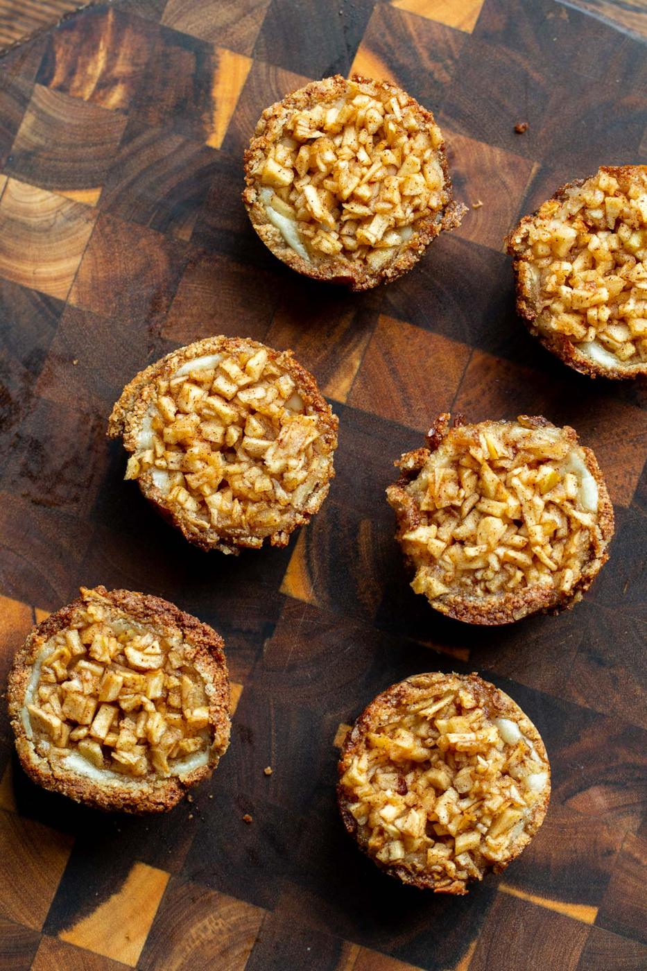 mini vegan apple cheesecake pies on a wooden board