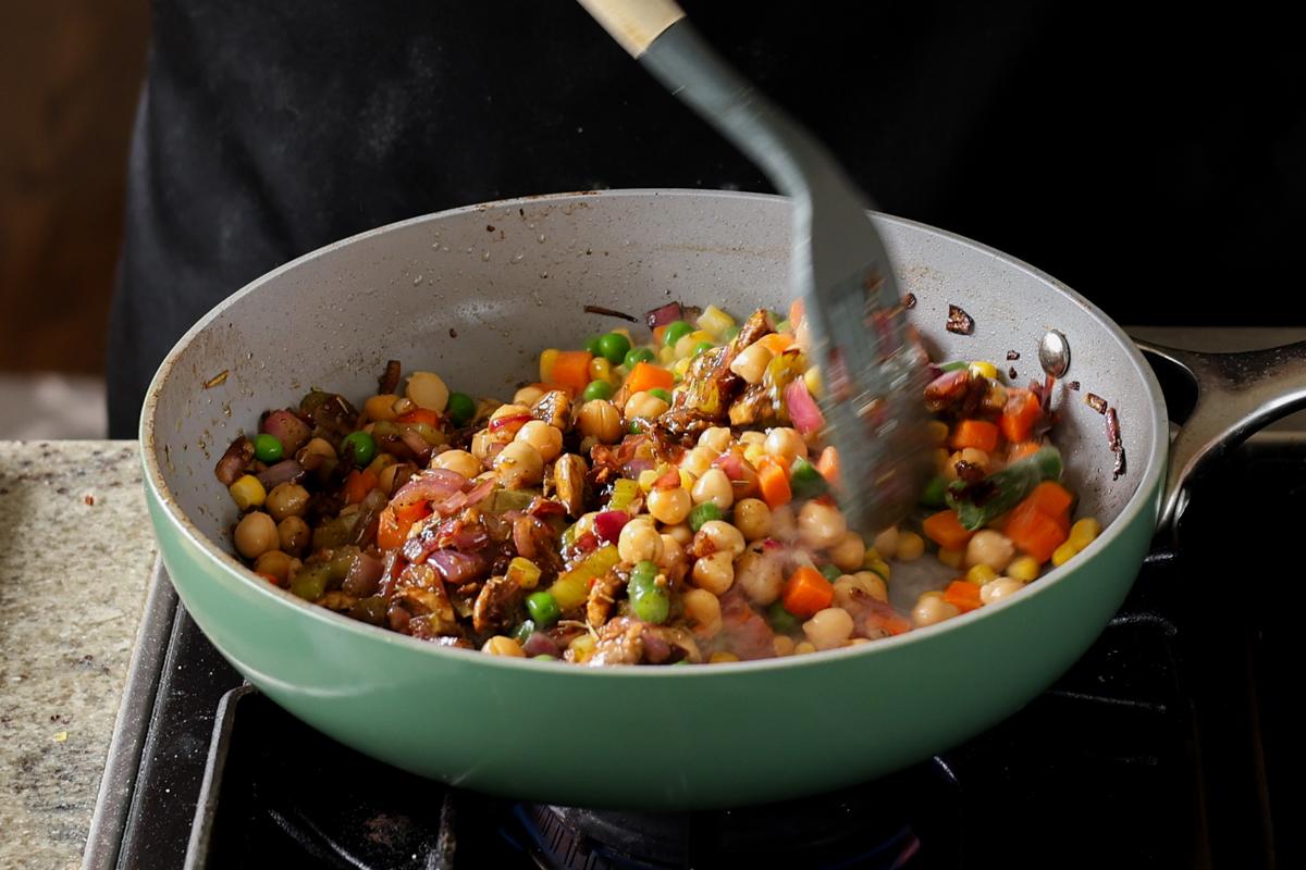 mixing the pot pie filling in the pan