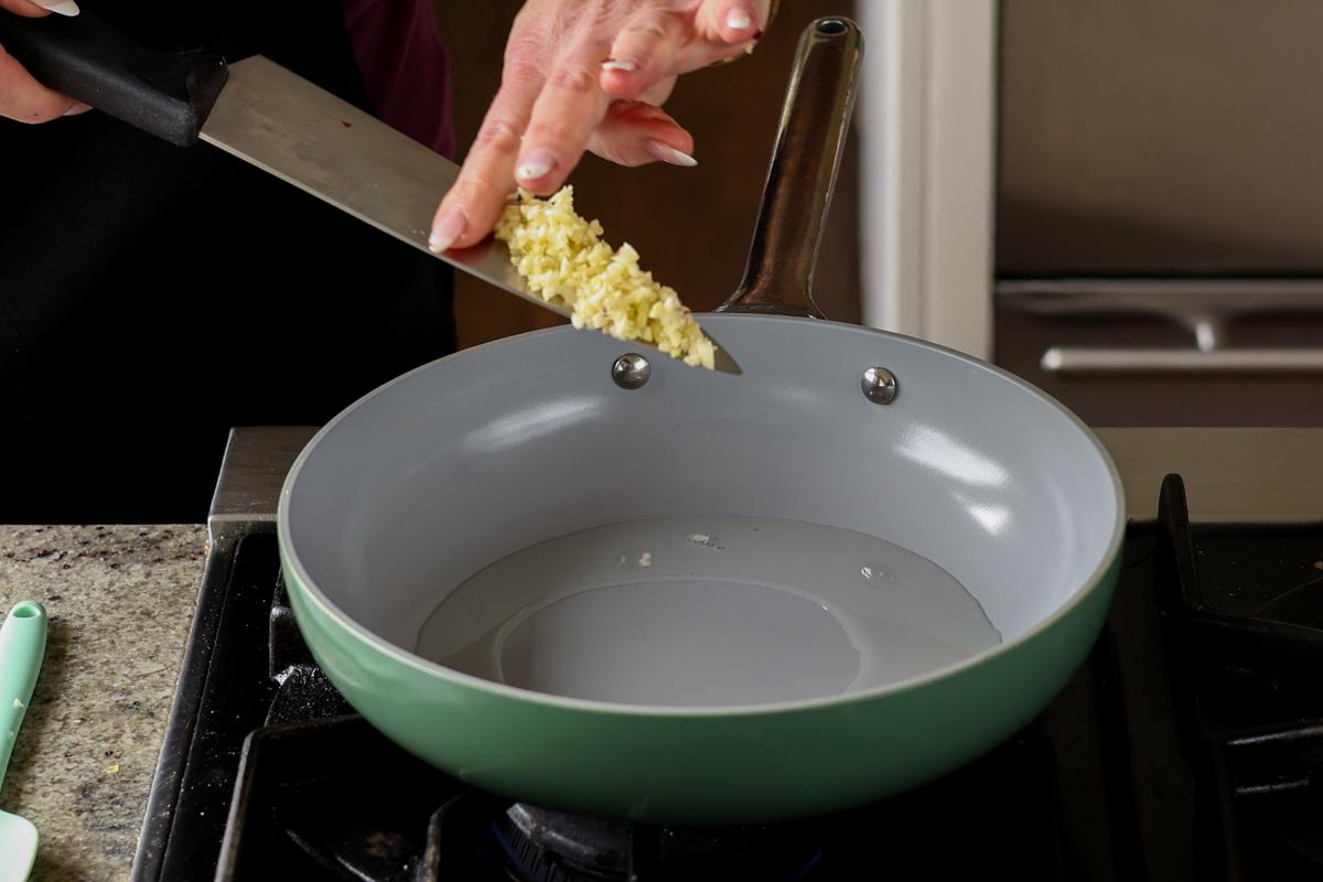 adding garlic to the pan