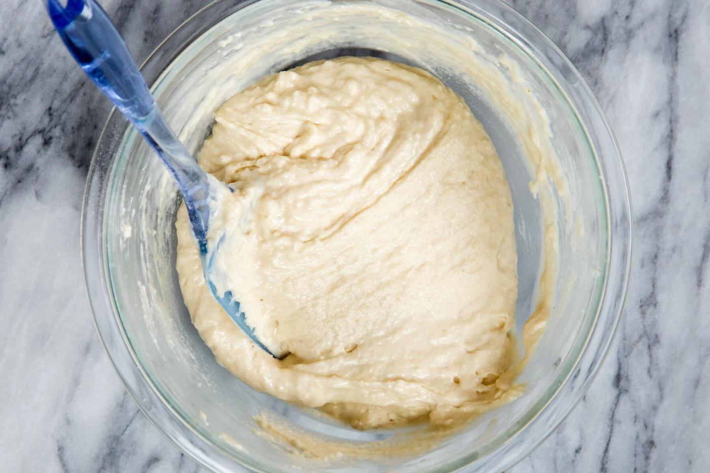vegan vanilla cake batter being stirred in a glass bowl