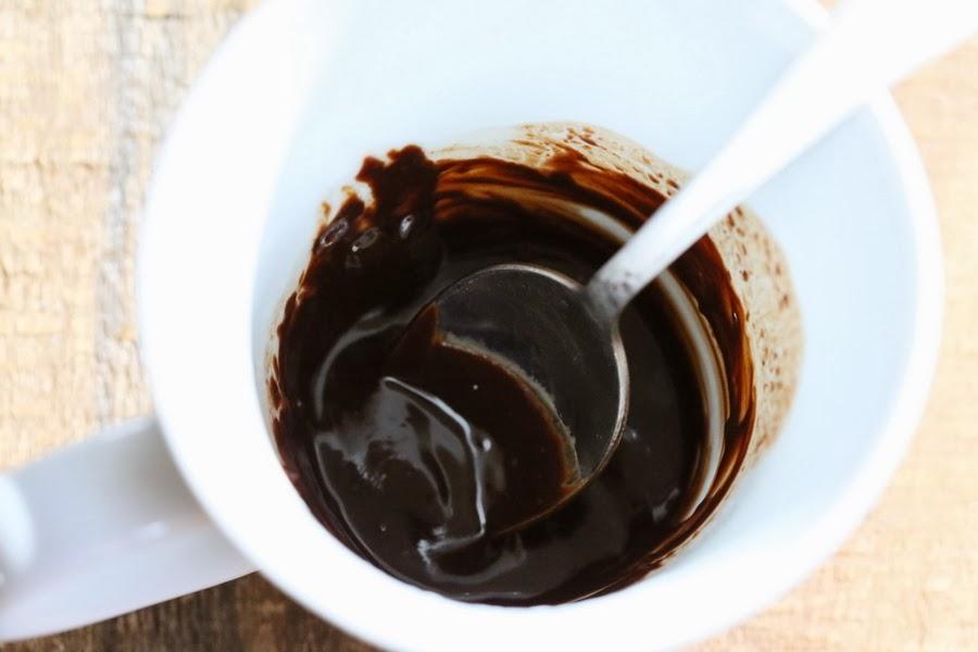 melted dark chocolate in a white cup with a spoon
