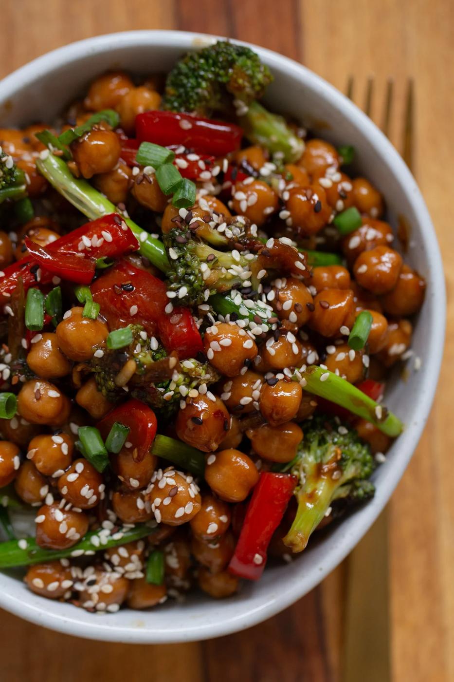 bowl of Mongolian chickpeas with sesame seeds on a wooden table