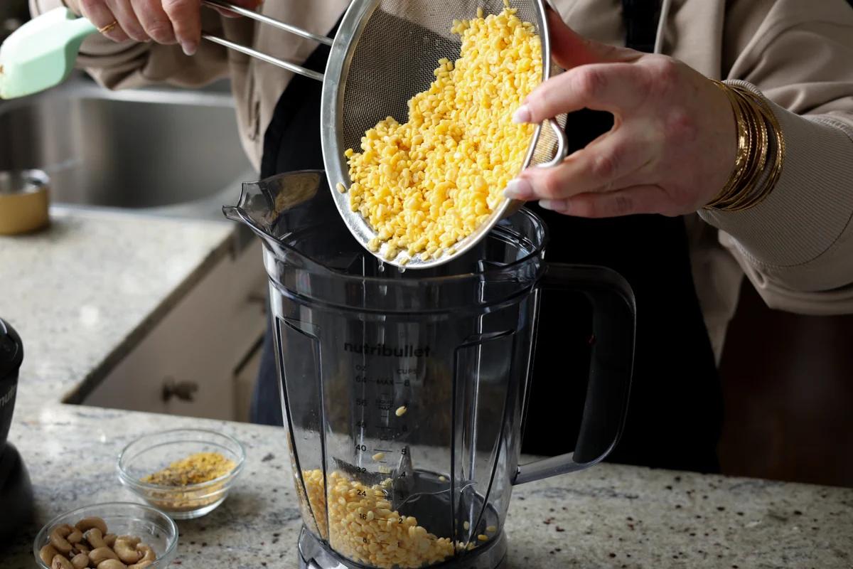 adding drained yellow lentils to the blender