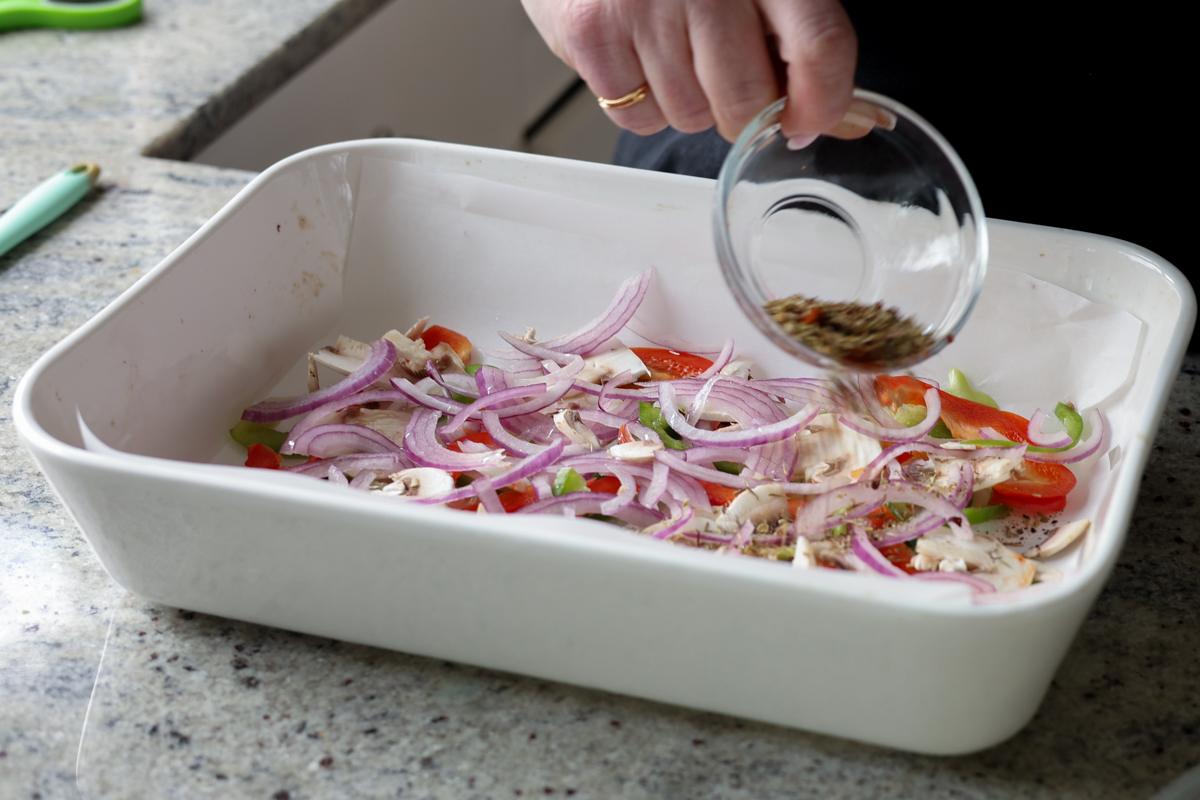 sprinkling spices over the veggies