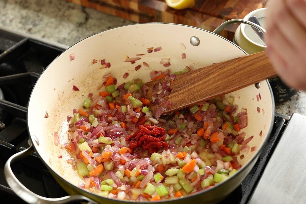 adding tomato paste to the pan
