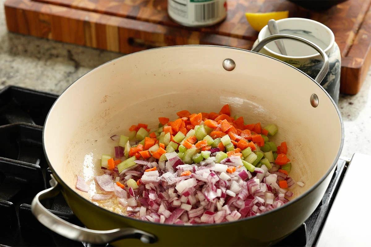 adding onion, carrots, and celery to the pan