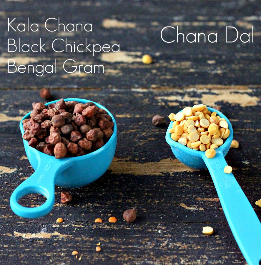 a small blue plastic measuring cup with black chickpeas next to a teaspoon with split peas