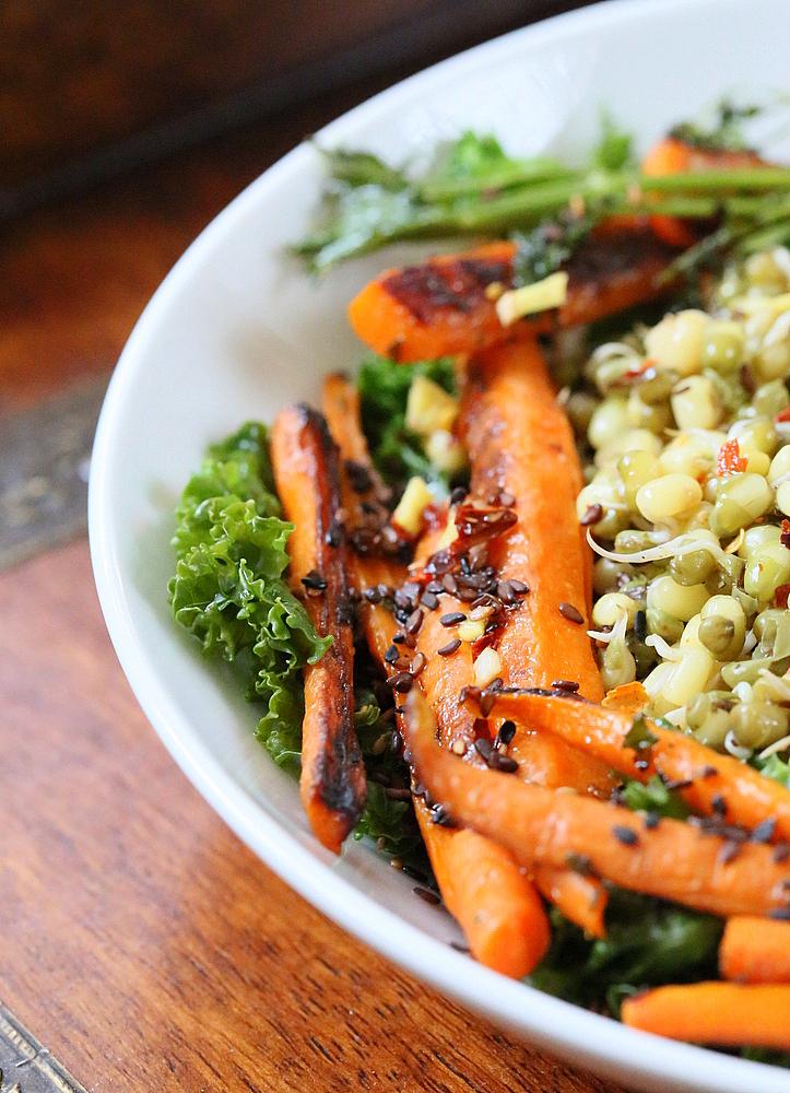 close-up of pan seared carrots and mung beans on a bed of kale
