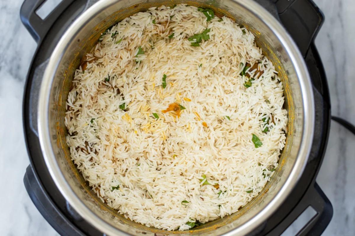 drained soaked rice being added to an Instant Pot with mushrooms and spices