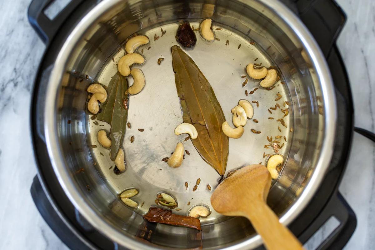 cashew nuts and spices frying in oil in an Instant Pot