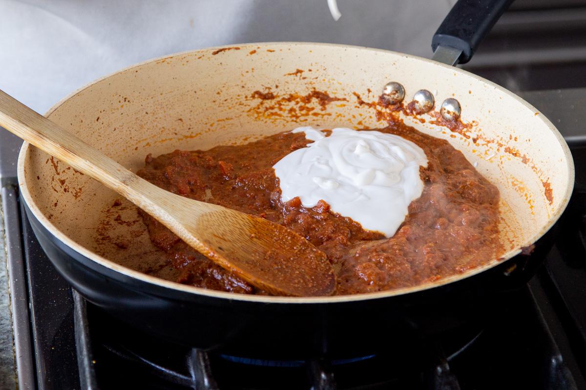 a dollop of vegan yogurt being added to a frying pan