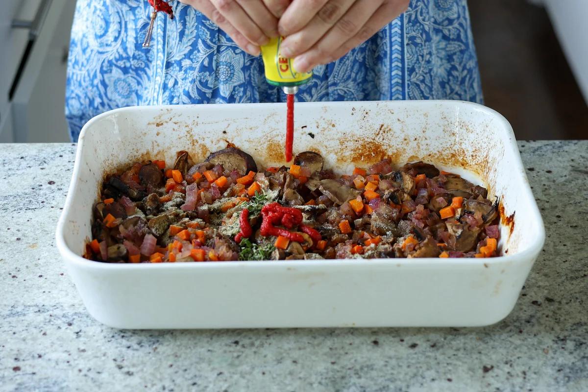 adding tomato paste to the baking pan