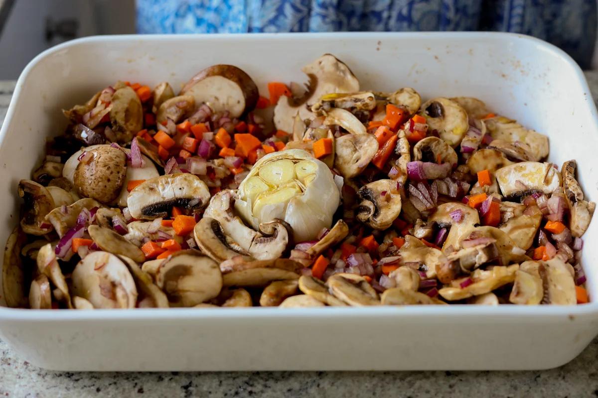 adding garlic head to the baking pan