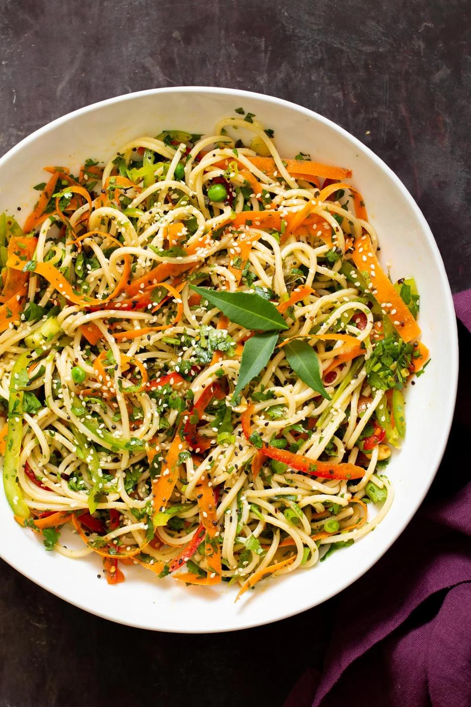 mustard chili oil spaghetti pasta salad sprinkled with sesame seeds and mint