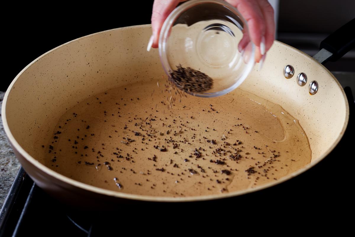 adding whole spices to the pan