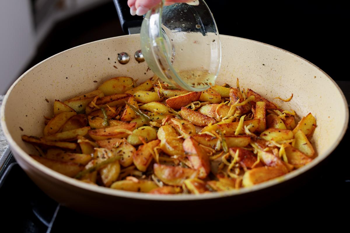adding vinegar to Nepali aloo