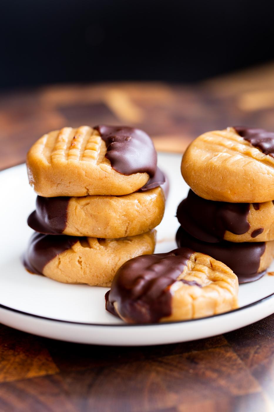 two stacks of no bake peanut butter cookies dipped in chocolate on a plate