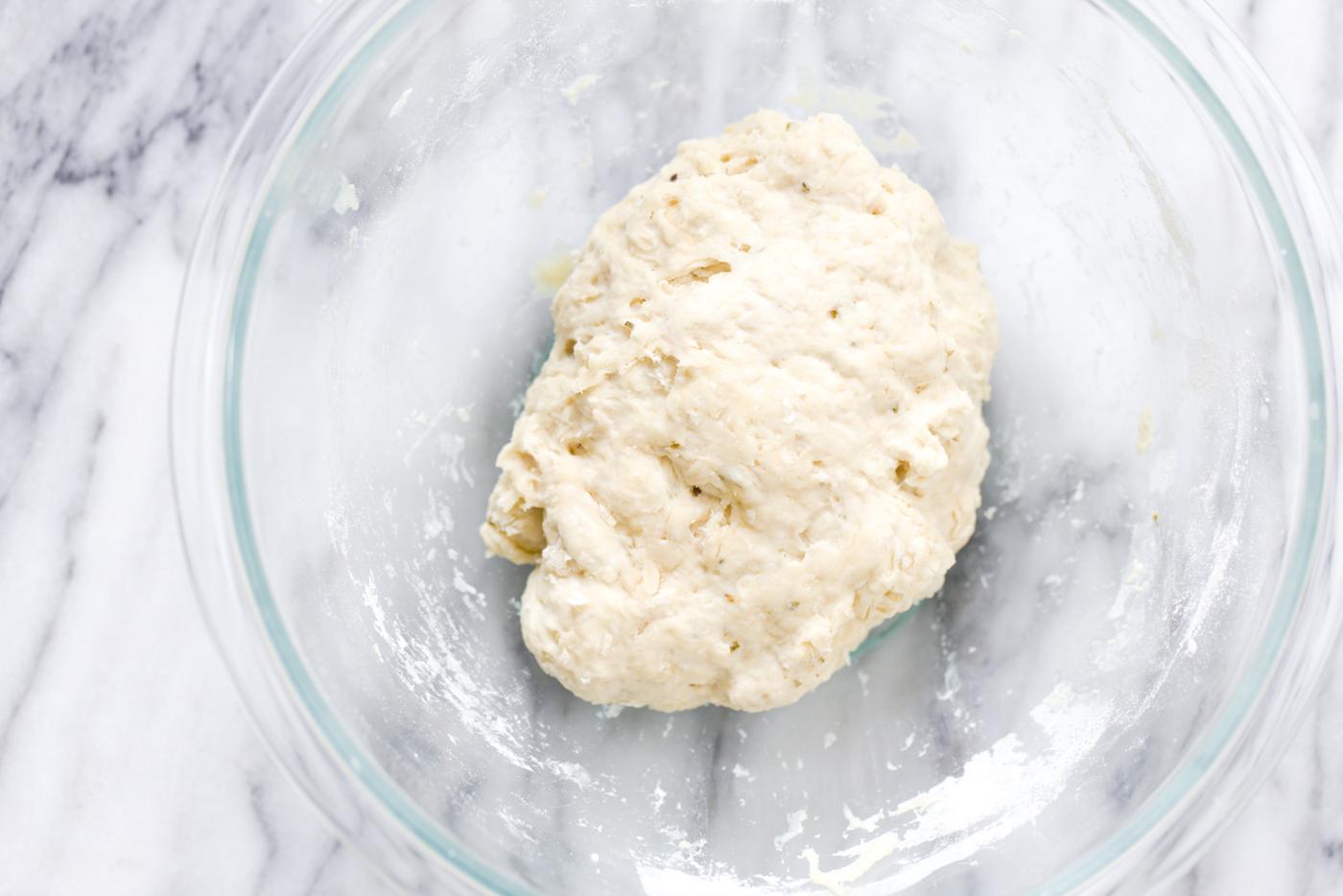 vegan yeast-free pizza dough being mixed in a glass bowl