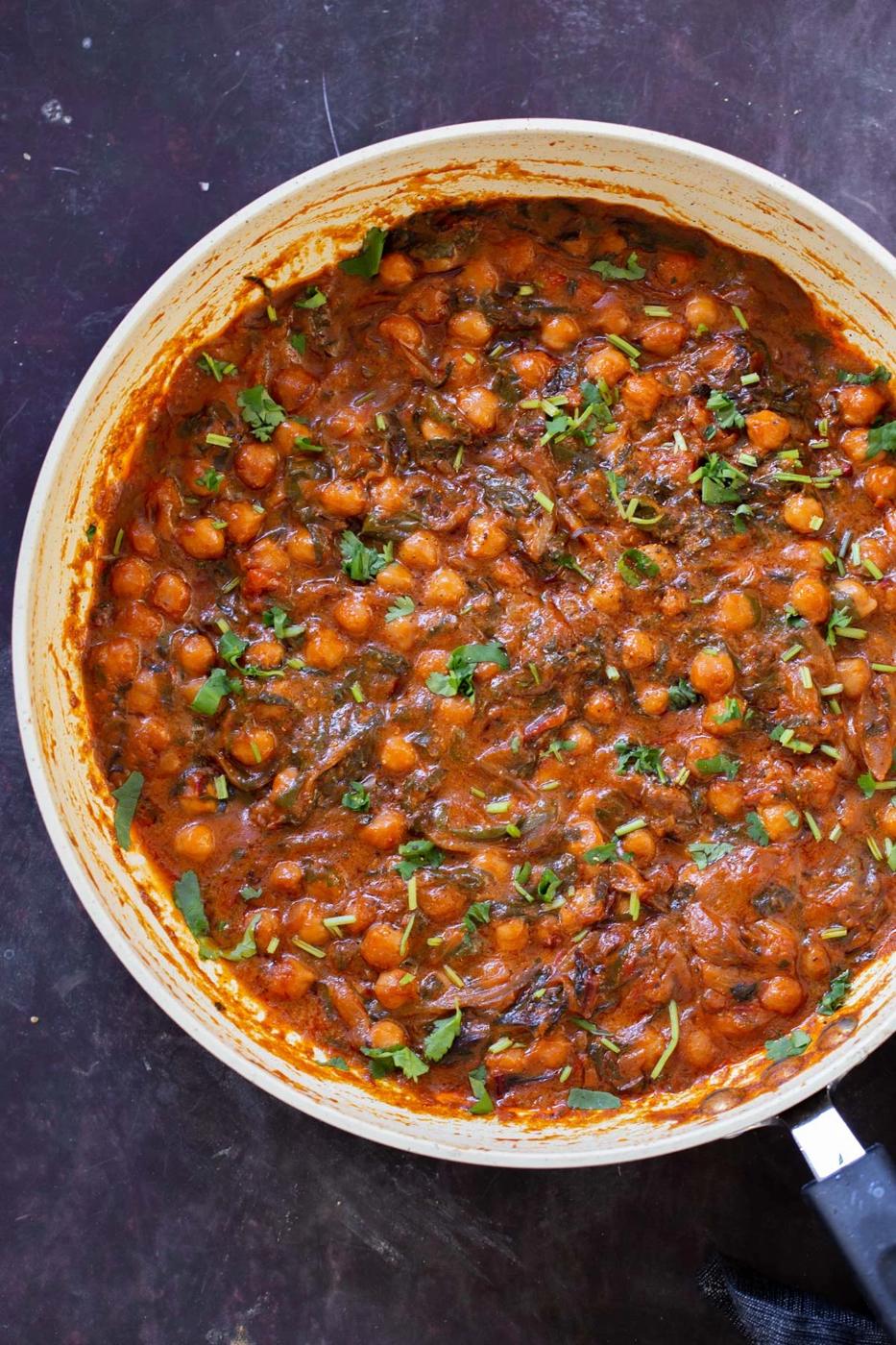panful of harissa chickpeas after cooking with cilantro garnish